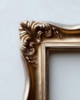 Ornate golden baroque frame corner with intricate floral scrollwork and decorative carved details against neutral background, showcasing luxurious vintage design elements.