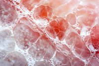 Abstract macro photography of pink salt crystals with bubbles and foam texture creating natural geometric patterns in coral and white tones.