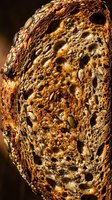 Whole grain bread slice with seeds and nuts, showcasing texture and nutritional ingredients for bakery, food photography, healthy eating, and culinary design projects.
