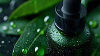 Closeup of green essential oil dropper bottle with water drops against fresh leaves background, creating spa wellness atmosphere for natural cosmetics.