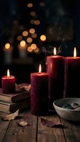 Red candles burning with warm flames on rustic wooden table creating cozy autumn atmosphere with bokeh lights and dried leaves for seasonal decor.