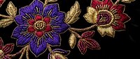 Luxurious embroidered floral pattern with gold thread on black fabric featuring ornate flowers and leaves for fashion and textile design projects.
