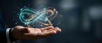 Businessman hand holding glowing atom symbol with orbital electrons, representing science, technology, innovation, and atomic energy for corporate and educational use.