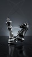 Metallic chess pieces king and knight on dark reflective surface with dramatic lighting for strategic business concepts and competitive thinking.