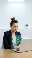 Professional businesswoman using laptop with holographic real estate icons in modern office for property technology and digital marketing solutions.