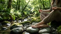 Young woman meditating barefoot by forest stream with moss-covered rocks. Peaceful nature wellness retreat for mindfulness and relaxation practices.