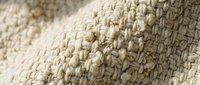 Close-up of natural beige knitted wool fabric texture with detailed stitching pattern for cozy home decor and fashion design projects.