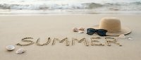 Word SUMMER written on sandy beach with straw hat, sunglasses, and seashells near ocean waves, evoking vacation and travel mood.