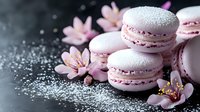 Pink macarons with delicate cherry blossoms on dark background with powdered sugar creating romantic atmosphere for food photography and confectionery marketing.