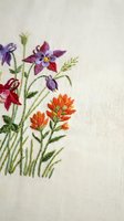 Delicate hand embroidered wildflowers on natural linen fabric featuring colorful blooms in purple, orange and red with green stems and leaves.