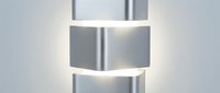Modern cylindrical wall lamp with brushed metal finish and integrated LED lighting, emitting warm glow for contemporary interior design and home decor applications.