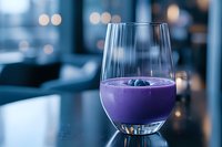Purple smoothie with blueberries in elegant wine glass on modern restaurant table with bokeh lights background for healthy lifestyle and nutrition.