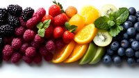 Fresh colorful fruits arranged in rainbow gradient pattern with blackberries, raspberries, strawberries, oranges, kiwi, and blueberries on white background, garnished with mint leaves.