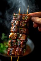 Grilled pork belly skewers with caramelized glaze and fresh herbs, steaming hot against dark background. Closeup shows juicy meat chunks on bamboo sticks.