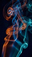 Colorful smoke swirls in orange and blue hues creating abstract flowing patterns against dark background for creative design projects.