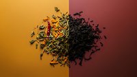 Artistic composition of loose tea leaves transitioning from green to black tea varieties, scattered on gradient orange to burgundy background. Perfect for tea packaging design.