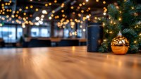 Festive coffee break setting with black tumbler and golden ornament on wooden table, decorated Christmas tree branches and blurred bokeh lights background.