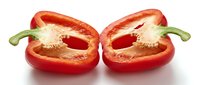 Red bell pepper halves with seeds removed, isolated on white background, ready for culinary design and food photography projects.