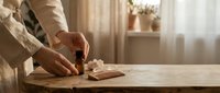 Professional aromatherapy session with essential oil bottle and natural spa accessories on wooden table in bright wellness center interior.