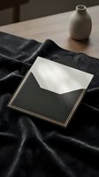 Elegant black envelope with gold trim and white card on dark silk fabric, minimalist stationery mockup for luxury wedding invitations and premium correspondence.