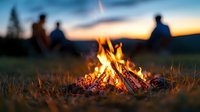 Glowing campfire with burning wood at sunset, silhouettes of friends sitting around fire in nature background, warm evening atmosphere in wilderness camping.