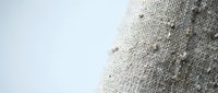 Natural linen fabric texture with visible weave pattern and organic fibers, neutral beige color for textile design and crafting projects.