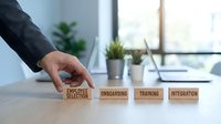 Business professional arranging wooden blocks showing employee lifecycle stages from selection to integration in modern office environment.