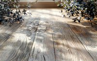 Rustic wooden planks with natural grain texture in sunlight, decorated with blue leaves creating soft shadows. Background for product photography and design.
