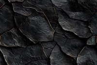 Dark fractured stone surface with glowing golden cracks creating dramatic abstract pattern. Natural luxury background for design projects.