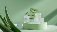 Fresh aloe vera slices with ice cubes on mint green podium against soft green background, minimalist skincare and beauty composition with natural shadows.