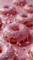 Pink glazed donuts with sprinkles in dreamy composition with water drops and soft bokeh effect, macro food photography on pink background.