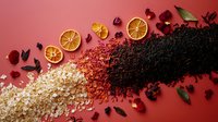 Gradient of tea varieties with dried orange slices and rose petals on red background, featuring black, red and white loose leaf tea arranged in creative composition.
