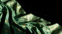 Luxurious green silk fabric with golden highlights flowing elegantly against dark background, showcasing rich texture and dramatic lighting for fashion design.
