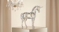 Crystal glass unicorn figurine on white pedestal in elegant interior with chandelier and curtains for luxury home decor and magical fantasy collection.