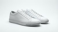Pair of white leather low-top sneakers on light background, minimalist style, clean design for fashion and lifestyle concepts.