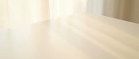 Empty wooden table surface with soft natural lighting and blurred background for product display and presentation purposes.