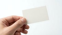 Hand holding blank white business card mockup on clean background for branding and corporate identity design projects.