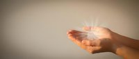 Open palm of a person with warm golden light radiating from hand, symbolizing hope, spirituality, healing energy, and positive transformation for wellness and inspirational concepts.