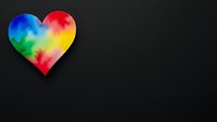 Vibrant rainbow heart symbol on black background with copy space for LGBTQ pride, love diversity concepts and graphic design projects.