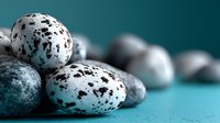 Speckled quail eggs with distinctive blue and brown pattern on turquoise background, creating elegant contrast for food photography and culinary design.