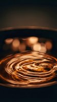 Swirling melted chocolate in mixing bowl with warm bokeh lights creating cozy baking atmosphere for culinary projects and dessert preparation concepts.
