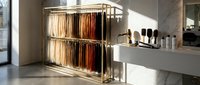 Modern kitchen interior with pull-out cabinet organizer displaying wooden cutting boards and cookware in contemporary home design with marble countertop.