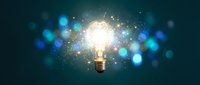 Glowing light bulb with sparkling particles and blue bokeh lights on dark background symbolizing creativity, innovation and bright ideas for business concepts.