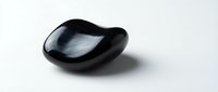 Smooth black obsidian stone with glossy surface isolated on white background for healing crystal meditation and spiritual wellness practices.
