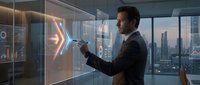 Man in business suit interacting with futuristic holographic display showing data analytics and charts in modern office with city skyline view.