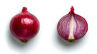 Fresh red onion whole and cut in half showing layers and texture on white background, isolated food ingredient for culinary and cooking designs.
