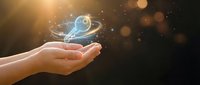 Cupped hand holding glowing digital bird with golden light particles and bokeh effects, symbolizing freedom, innovation, and technology concepts for business and digital transformation projects.