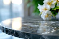 Luxurious black marble surface with natural veining pattern and soft bokeh background featuring white flowers, elegant home decor and interior design element.