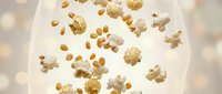Golden confetti and sparkles floating in warm bokeh light creating festive celebration atmosphere for party decorations and holiday designs.