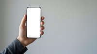 Hand holding smartphone with blank white screen against neutral background, suitable for app mockups, mobile technology presentations, and digital marketing campaigns.